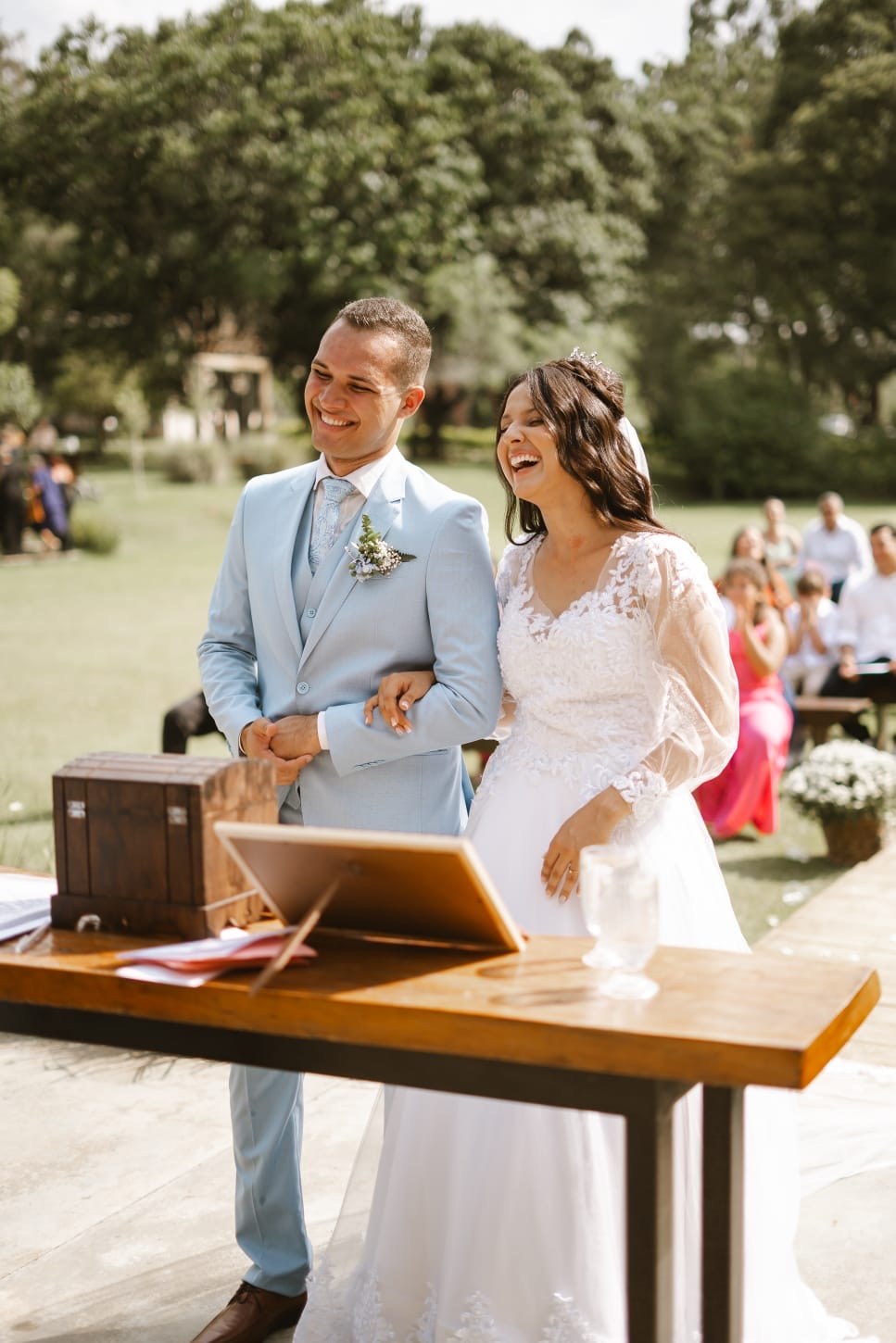 Casal emocionado e sorridente em cerimônia ao ar livre